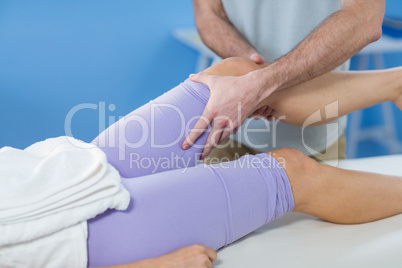 Male physiotherapist giving knee massage to female patient