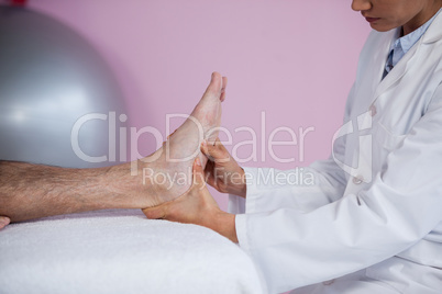 Senior man receiving foot massage from physiotherapist