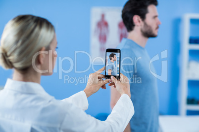 Physiotherapist clicking photo of a male patient