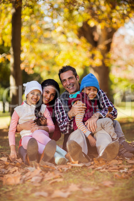 Happy family sitting at park during autumn