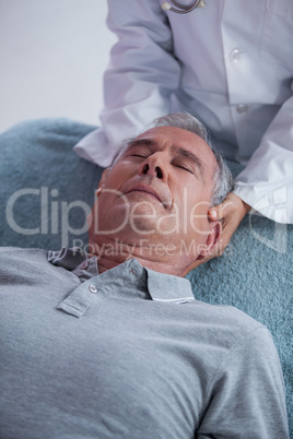 Senior man receiving neck massage from physiotherapist