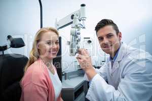 Optometrist examining female patient on phoropter