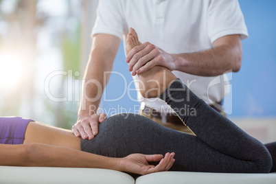 Male physiotherapist giving knee massage to female patient