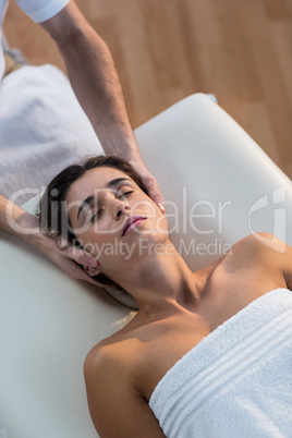 Male physiotherapist giving head massage to female patient