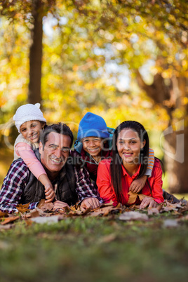 Happy family lying on field during autumn