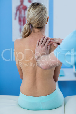 Male physiotherapist giving shoulder massage to female patient