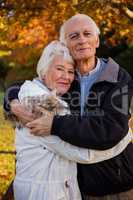 Smiling senior couple embracing at park