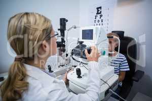 Female optometrist examining young patient on coreometry