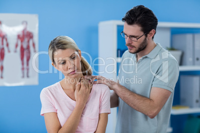 Physiotherapist stretching neck of a female patient