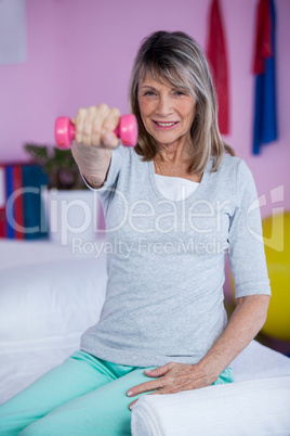 Portrait of senior woman holding dumbbell