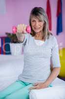 Portrait of senior woman holding dumbbell