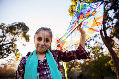 Low angle portrait of girl holding kite