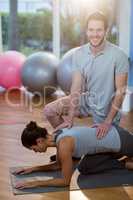 Physiotherapist assisting a female patient while exercising