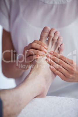 Physiotherapist giving foot massage to a patient