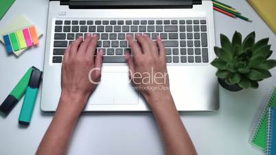 Woman's hands typing on laptop keyboard