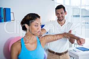 Physiotherapist examining womans shoulder