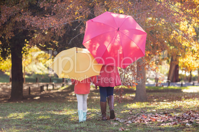 Mother and daughter with umbrella at park