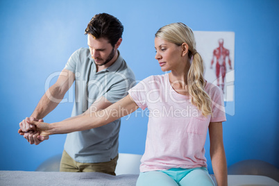 Physiotherapist massaging hand of a female patient