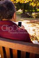 Man using cellphone while relaxing on bench