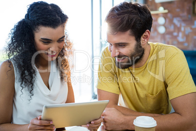 Couple using a digital tablet in coffee shop