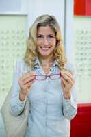 Smiling female customer trying spectacles