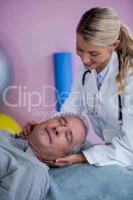 Senior man receiving neck massage from physiotherapist