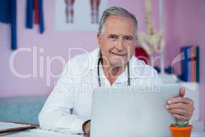 Portrait of physiotherapist using laptop