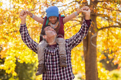 Father carrying son on shoulder at park