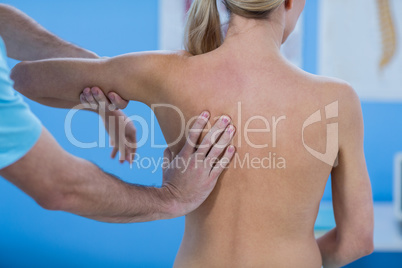Male physiotherapist giving back massage to female patient