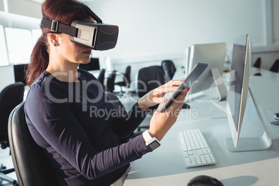 Mature student in virtual reality headset using digital tablet