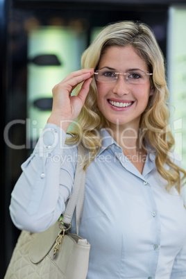 Smiling female customer trying spectacles