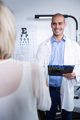 Male optometrist talking to female patient