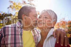 An elderly man kissing his wife