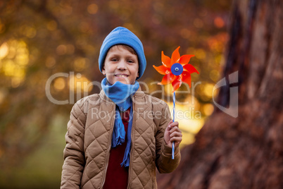Portrait of smiling boy holding pinwheel at park