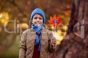 Portrait of smiling boy holding pinwheel at park
