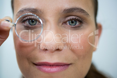 Female optometrist looking through magnifying glass