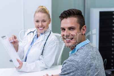 Smiling female doctor explaining prescription to patient on clip