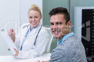 Smiling female doctor explaining prescription to patient on clip
