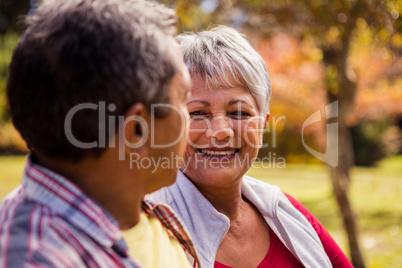 Elderly couple looking at each other while sitting on the bench