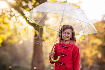 Portrait of cute girl with umbrella at park