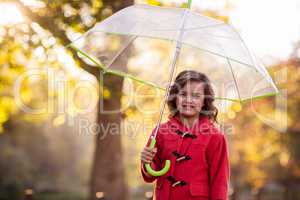 Portrait of cute girl with umbrella at park