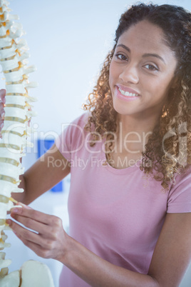 Portrait of woman holding spine model