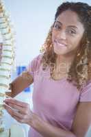 Portrait of woman holding spine model