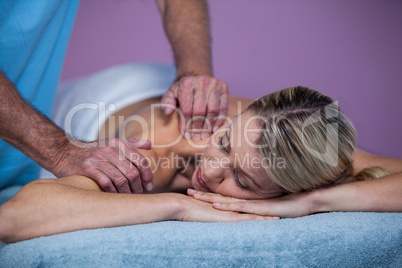 Woman receiving shoulder massage from physiotherapist