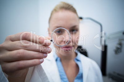 Female optometrist looking through magnifying glass