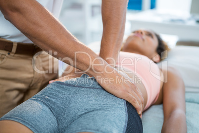 Physiotherapist giving stomach massage to a woman