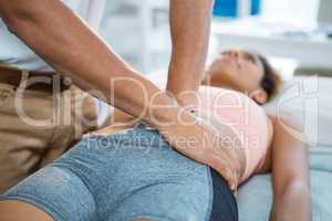 Physiotherapist giving stomach massage to a woman