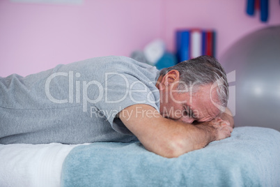 Senior man lying on a massage bed