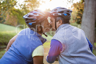 Senior couple kissing on their bike