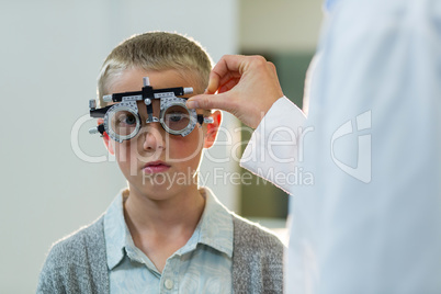 Optometrist examining young patient with phoropter
